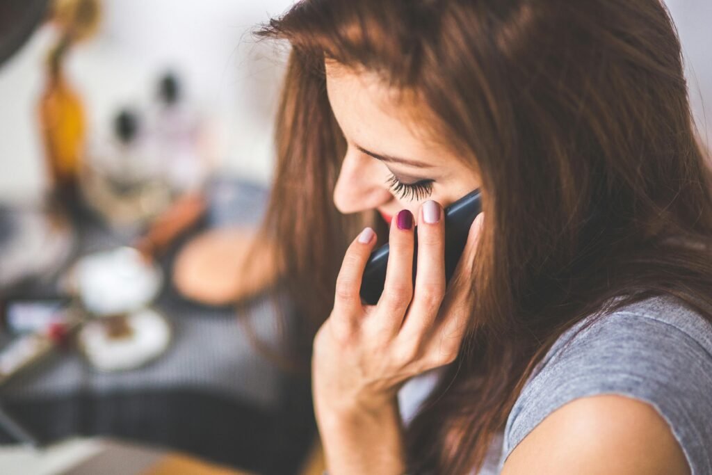 Close-up of a woman conversing on a smartphone indoors during the day.