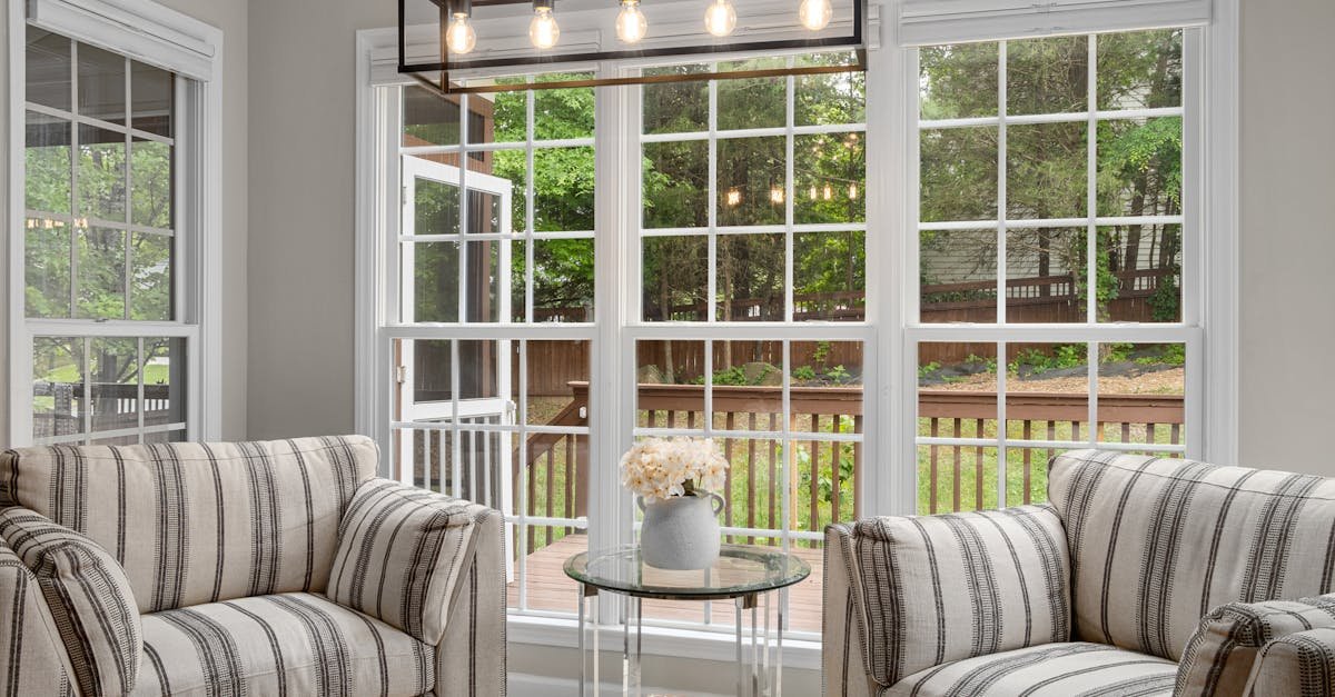 Elegant living room with striped armchairs and large windows overlooking a garden.